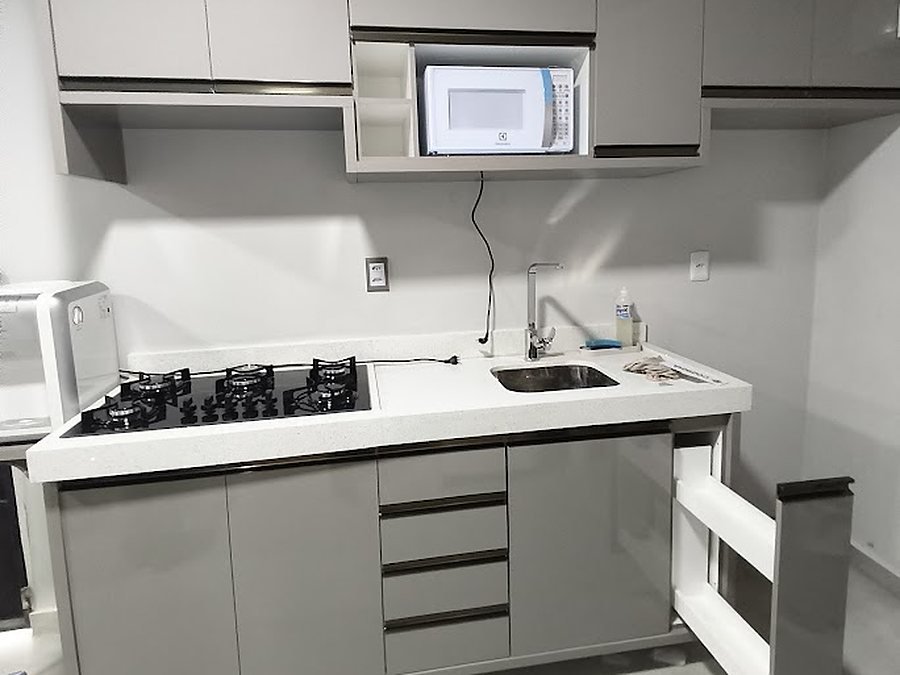 Cozinha planejada em MDF Branco Fumê com puxador perfil champanhe polido, cooktop, cuba e nicho embutido para micro-ondas, bairro Buritis, Boa Vista – RR